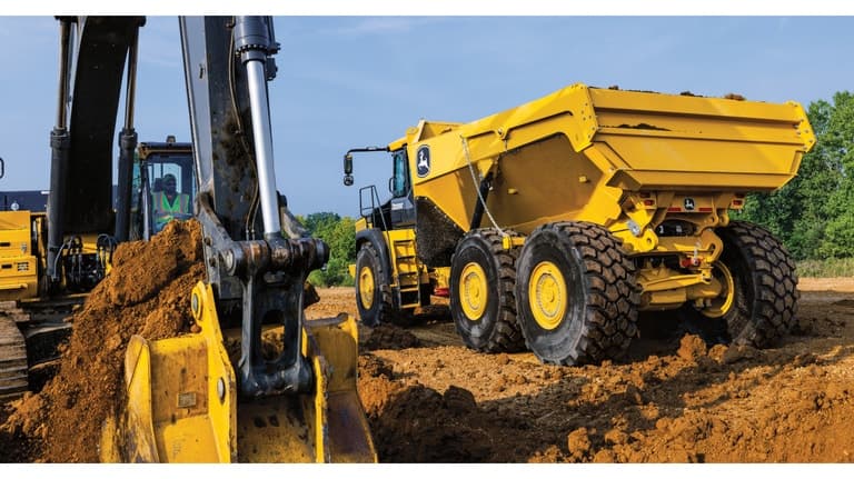 A 410P Articulated Dump Truck waiting to be loaded with dirt from a nearby excavator. | 4re Equipment