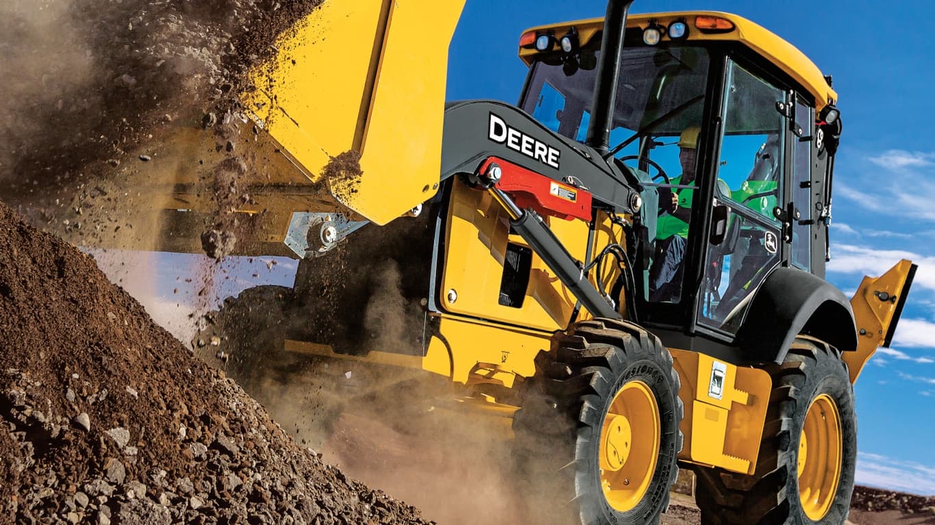 Close-up of an operator dumping dirt from a 310G Backhoe bucket. | 4re Equipment | ID: 310GBH