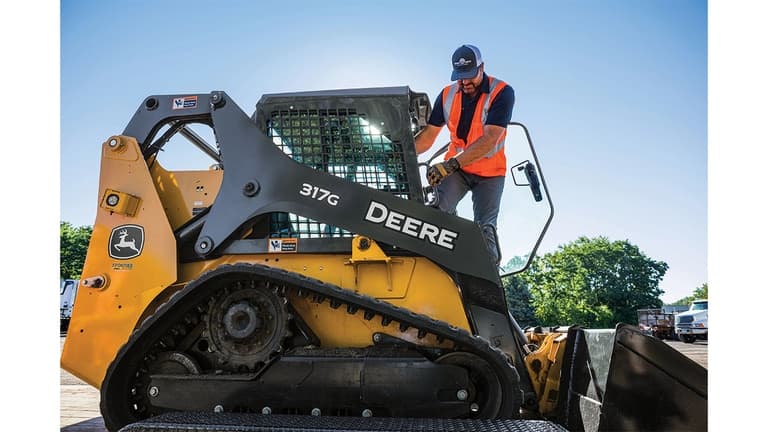 An operator climbing out of a 317G Compact Track Loader. | 4re Equipment