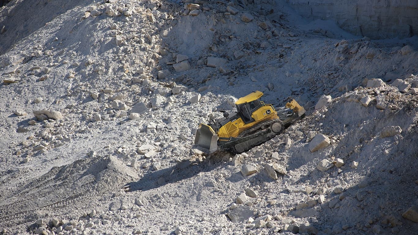 A 1050K Dozer pushing rock at a quarry worksite. | 4re Equipment | ID: 1050kt