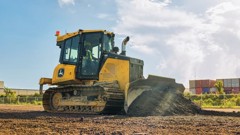 Right-side view of a 650P Dozer pushing dirt at a worksite. | 4re Equipment