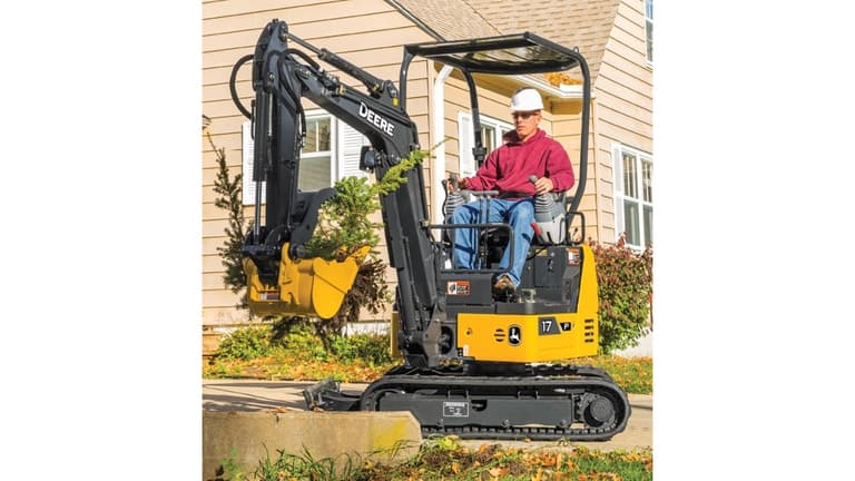 Man using 17P-Tier Excavator to move plants in front of a house. | 4re Equipment