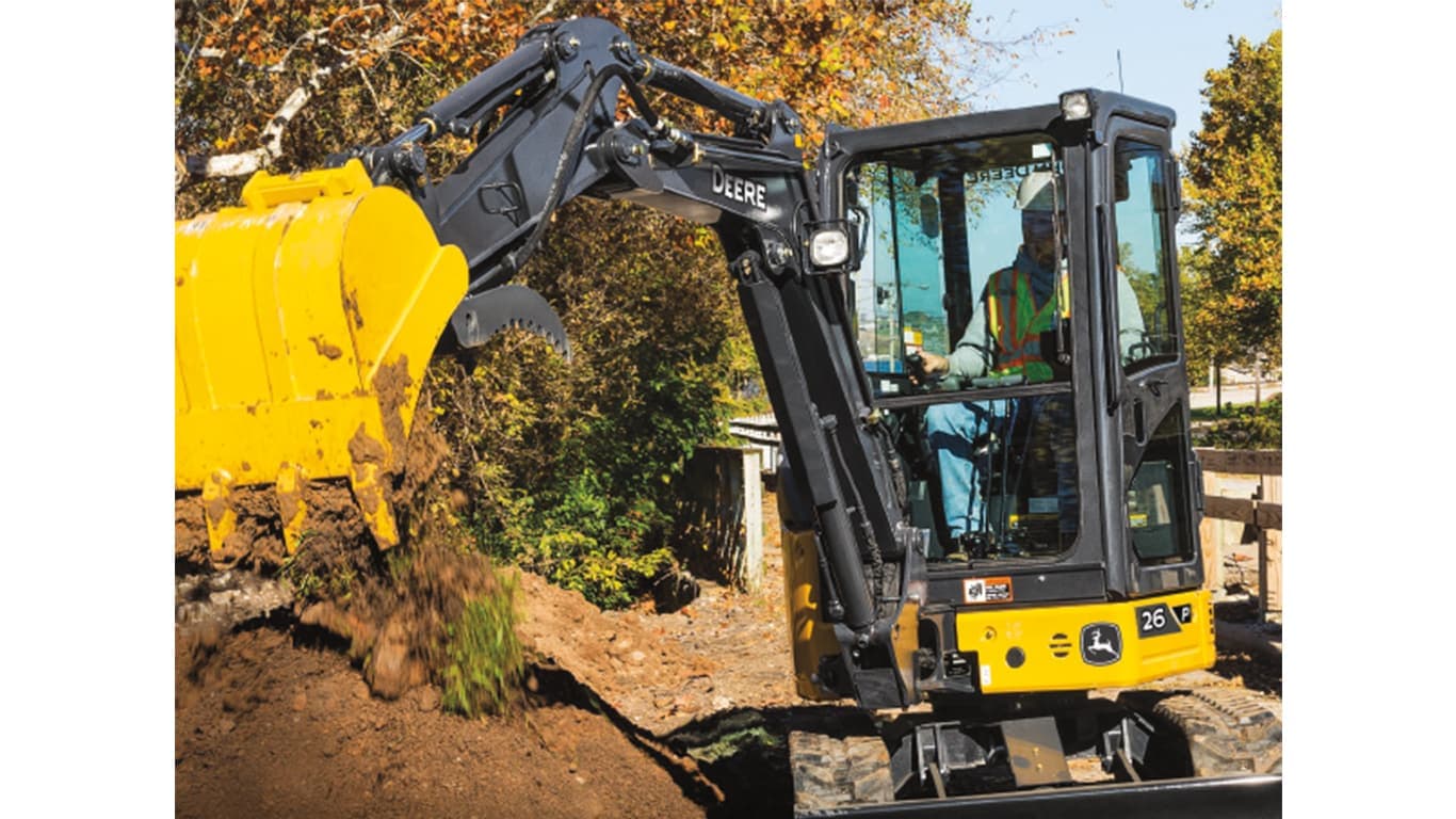 An operator using a 26P-Tier Excavator to dump dirt onto a pile in front of a fence. | 4re Equipment | ID: 26PEXFT4