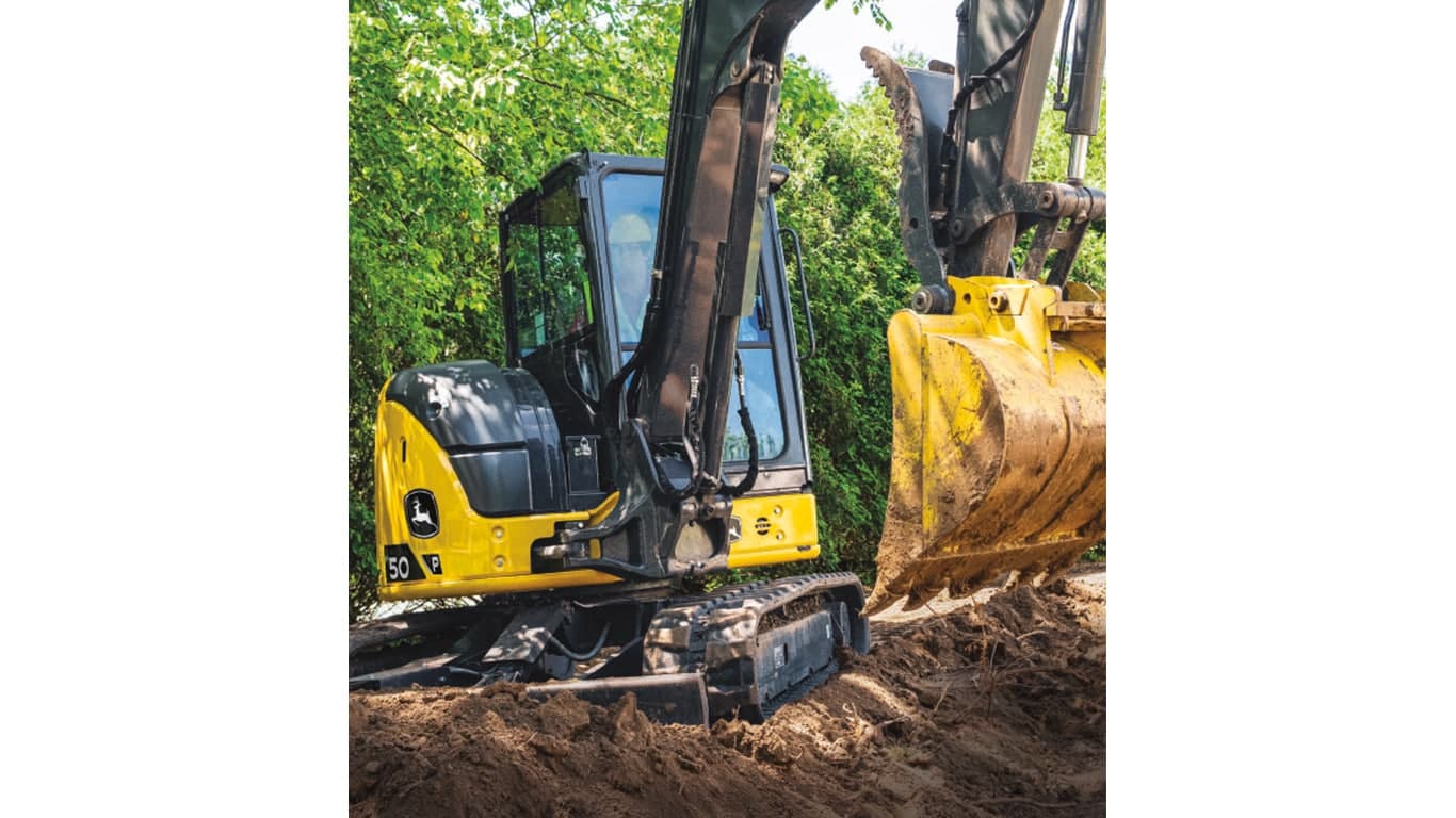 A 50P-Tier Excavator moving dirt with trees in the background. | 4re Equipment | ID: 50PEXFT4