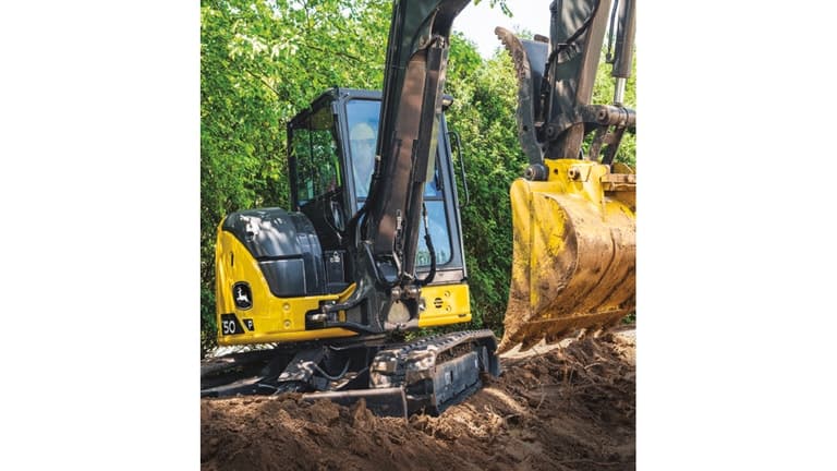 A 50P-Tier Excavator moving dirt with trees in the background. | 4re Equipment
