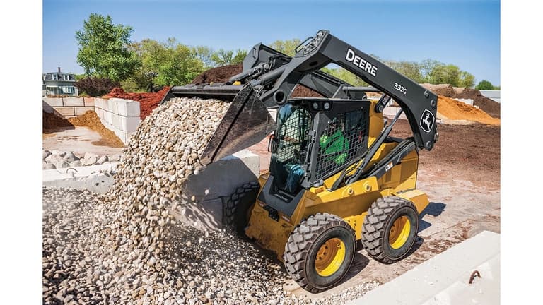A 332G Skid Steer dumping rocks at a worksite. | 4re Equipment